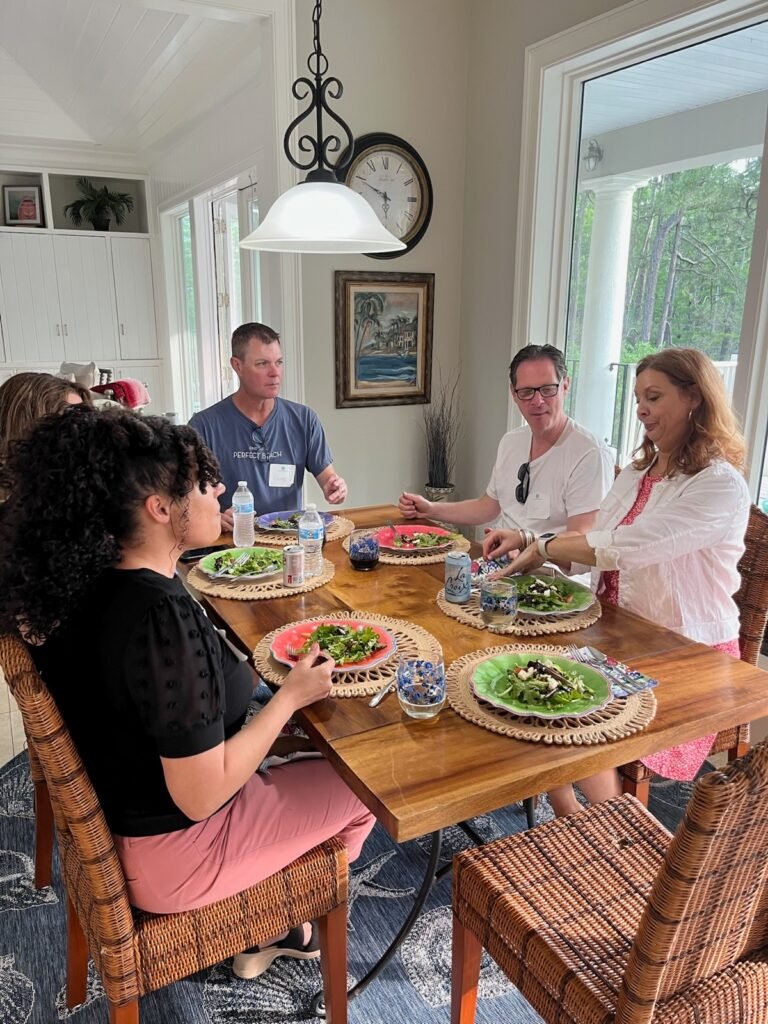 Michelle Prince and a small group gathered around a table at a Book Bound Experience retreat session.