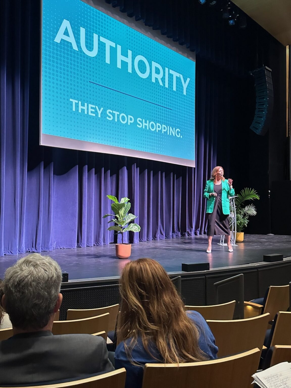 Michelle Prince speaking on stage at a keynote event.